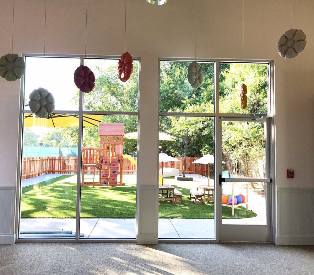 View through windows of an outdoor playground with a wooden playset