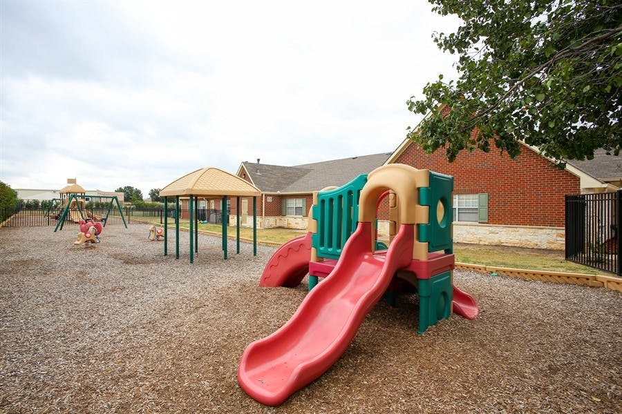 Playground with a red slide and other play equipment