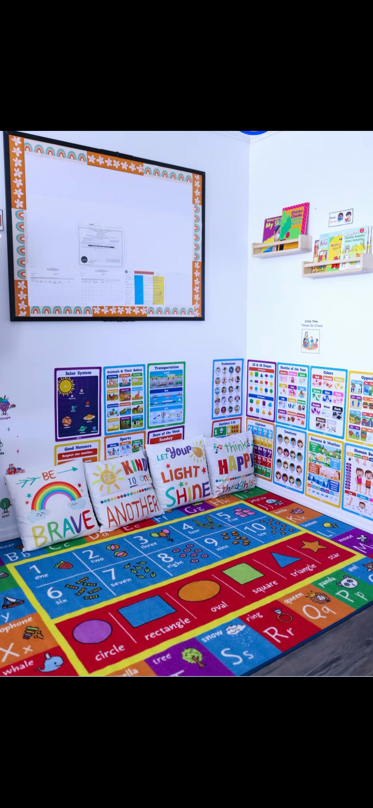 Corner of a classroom with an alphabet rug, pillows, and educational posters