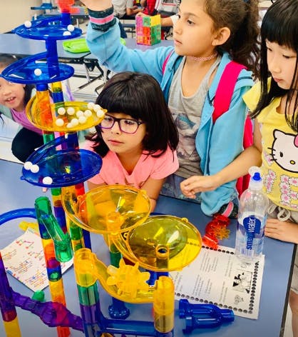 Children playing with a colorful marble run toy