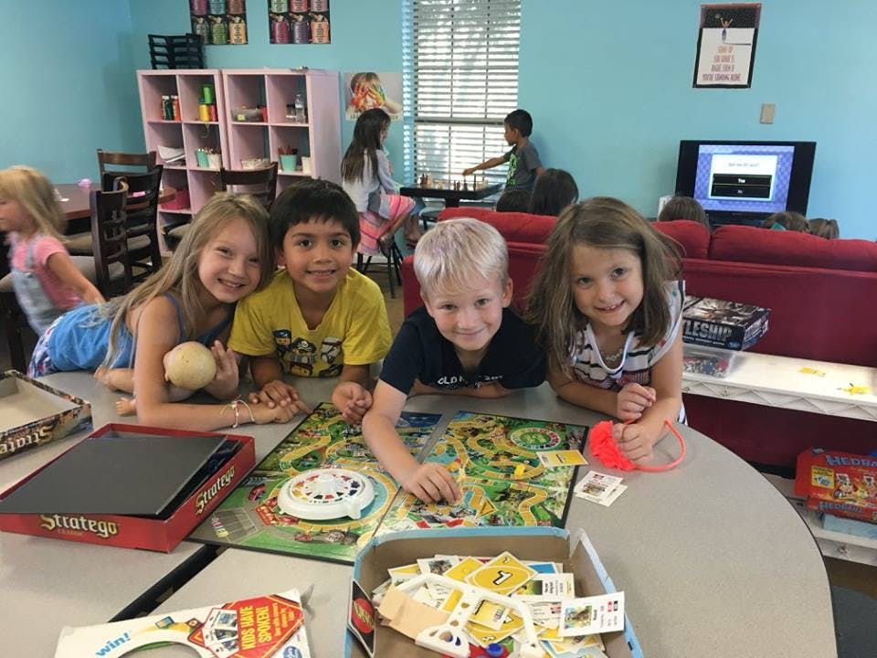 Four children playing a board game at a table