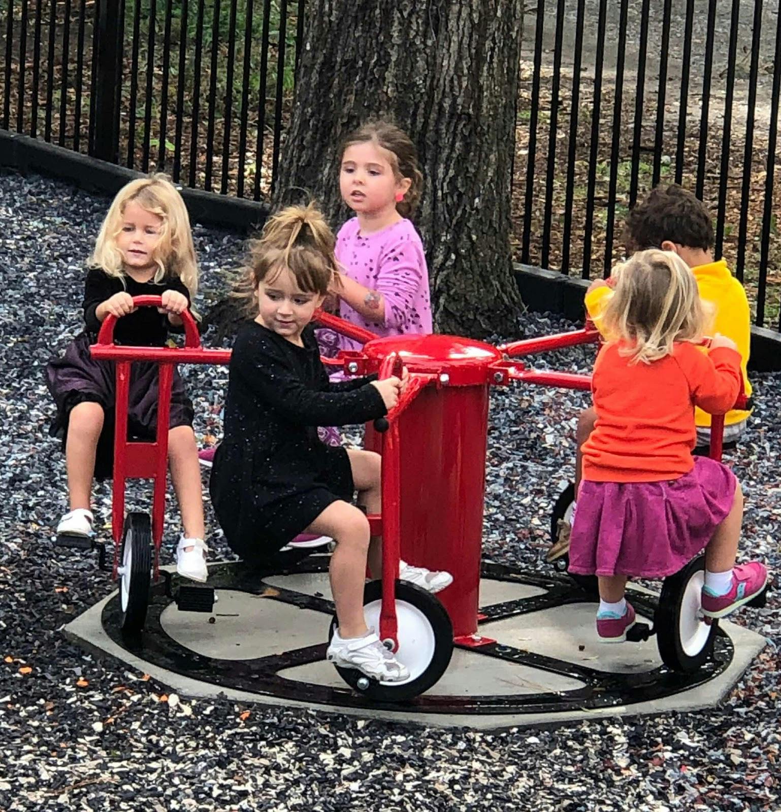 Children on a red playground merry-go-round