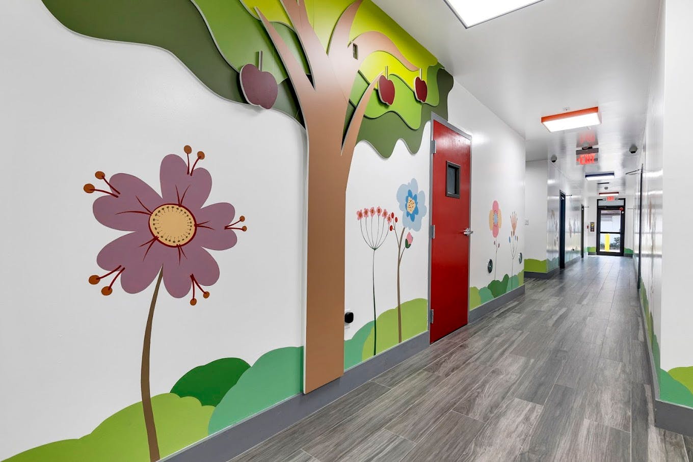 Hallway with colorful tree and flower murals on the wall