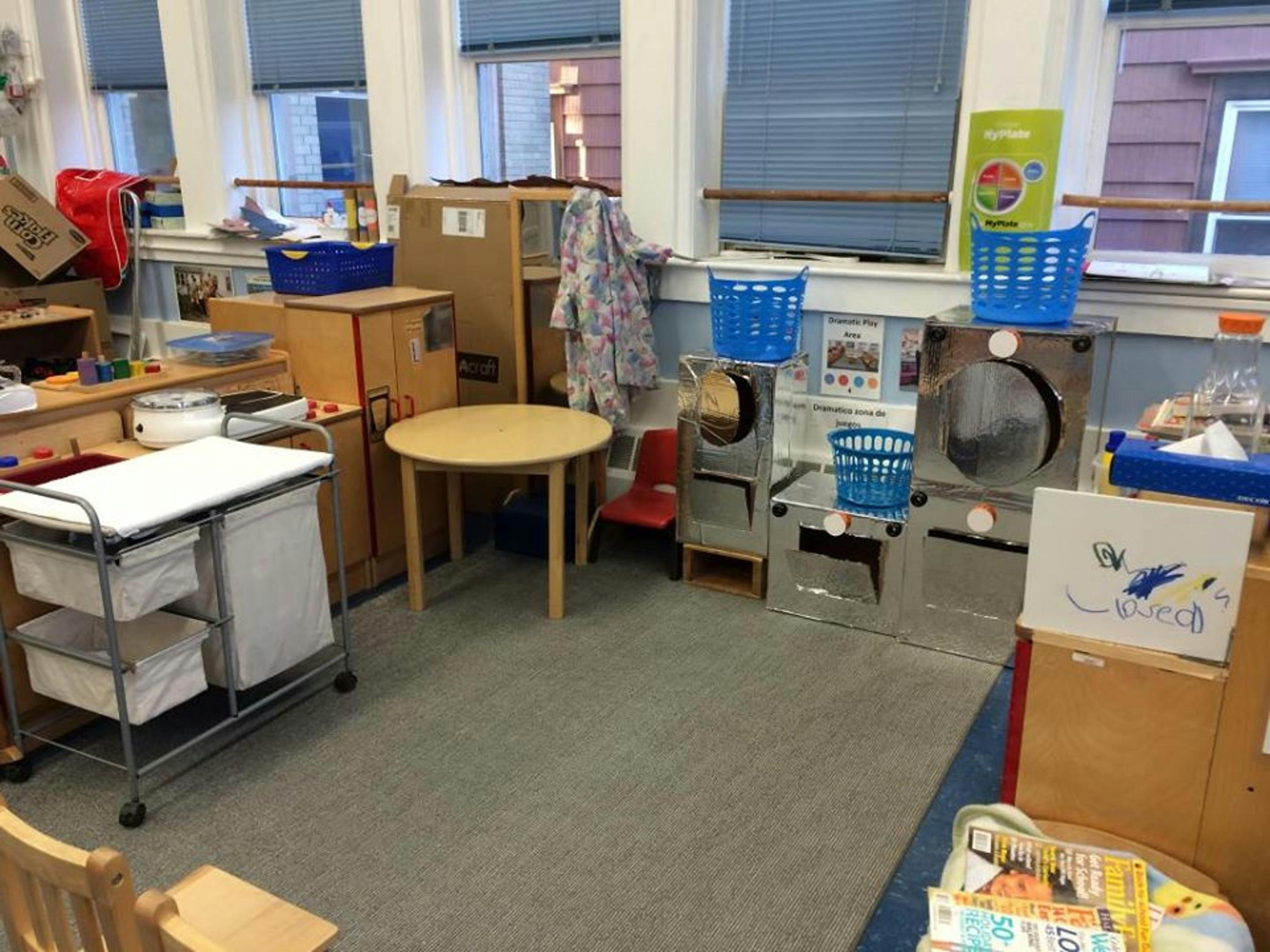 Playroom with a small round table, laundry cart, and toy appliances
