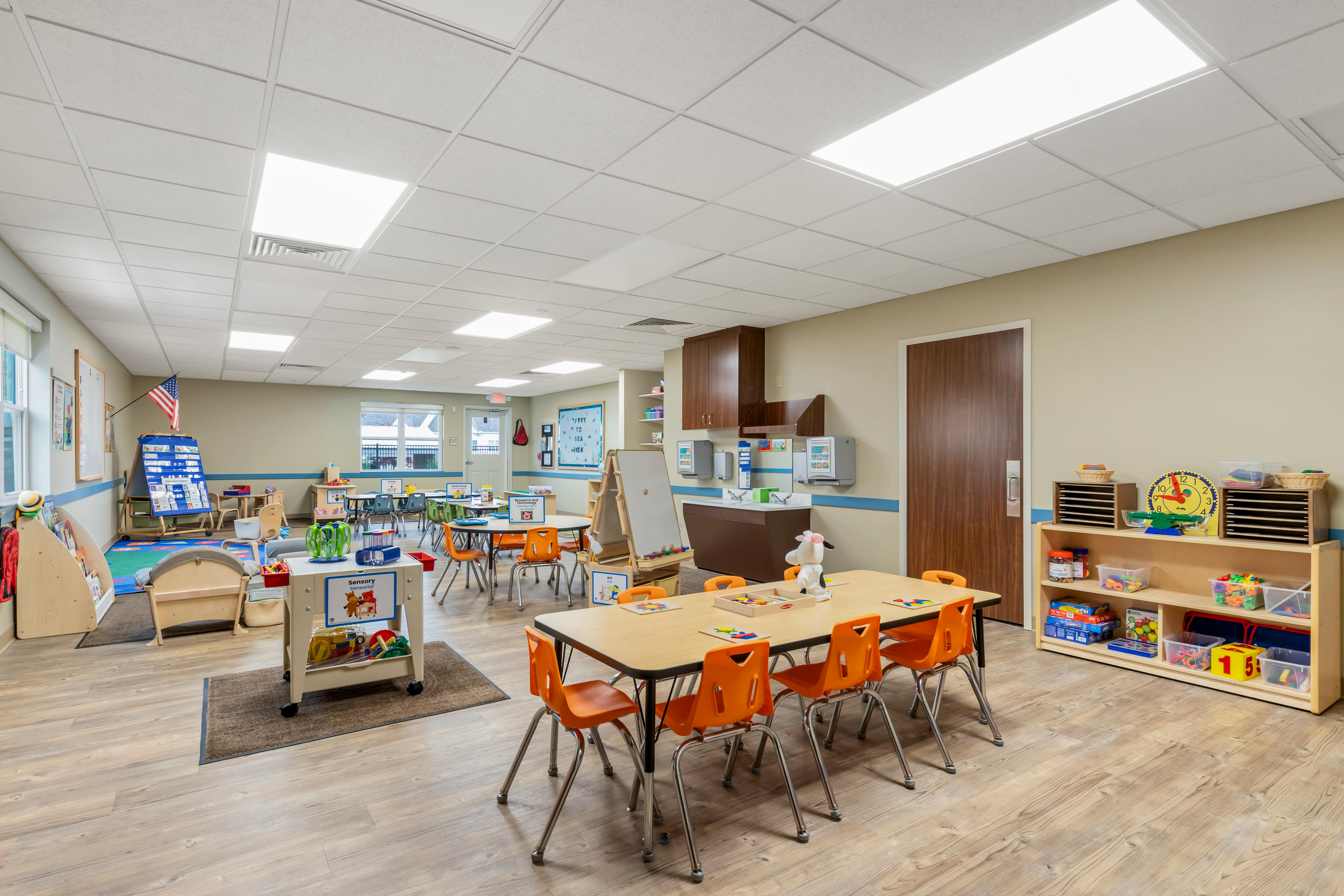 Classroom with children's tables and chairs, play areas, and educational materials