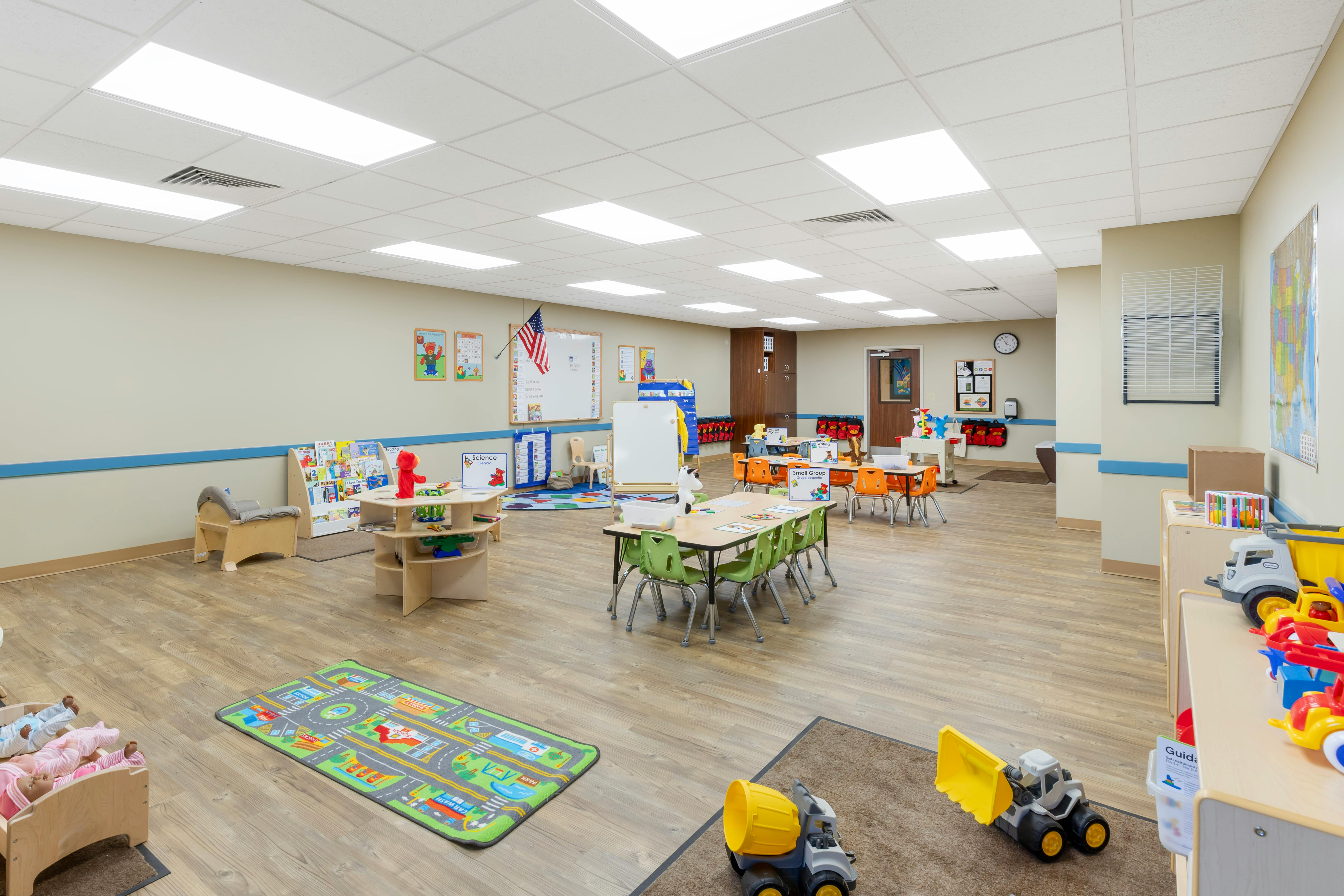 Classroom with tables, chairs, toys, books, and educational displays