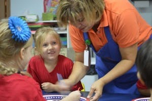 Adult and two children interacting at a table
