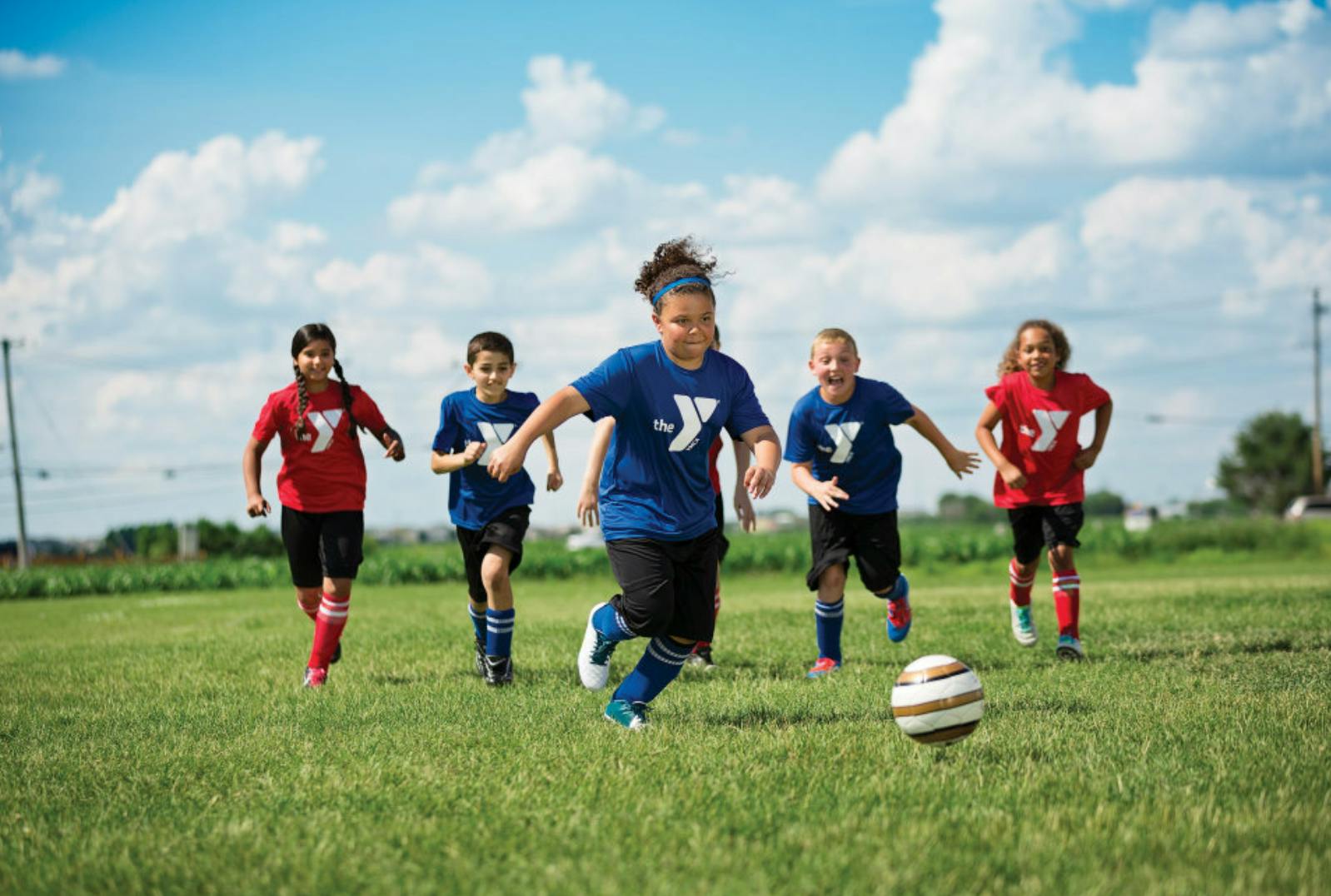 Children playing soccer on a grassy field