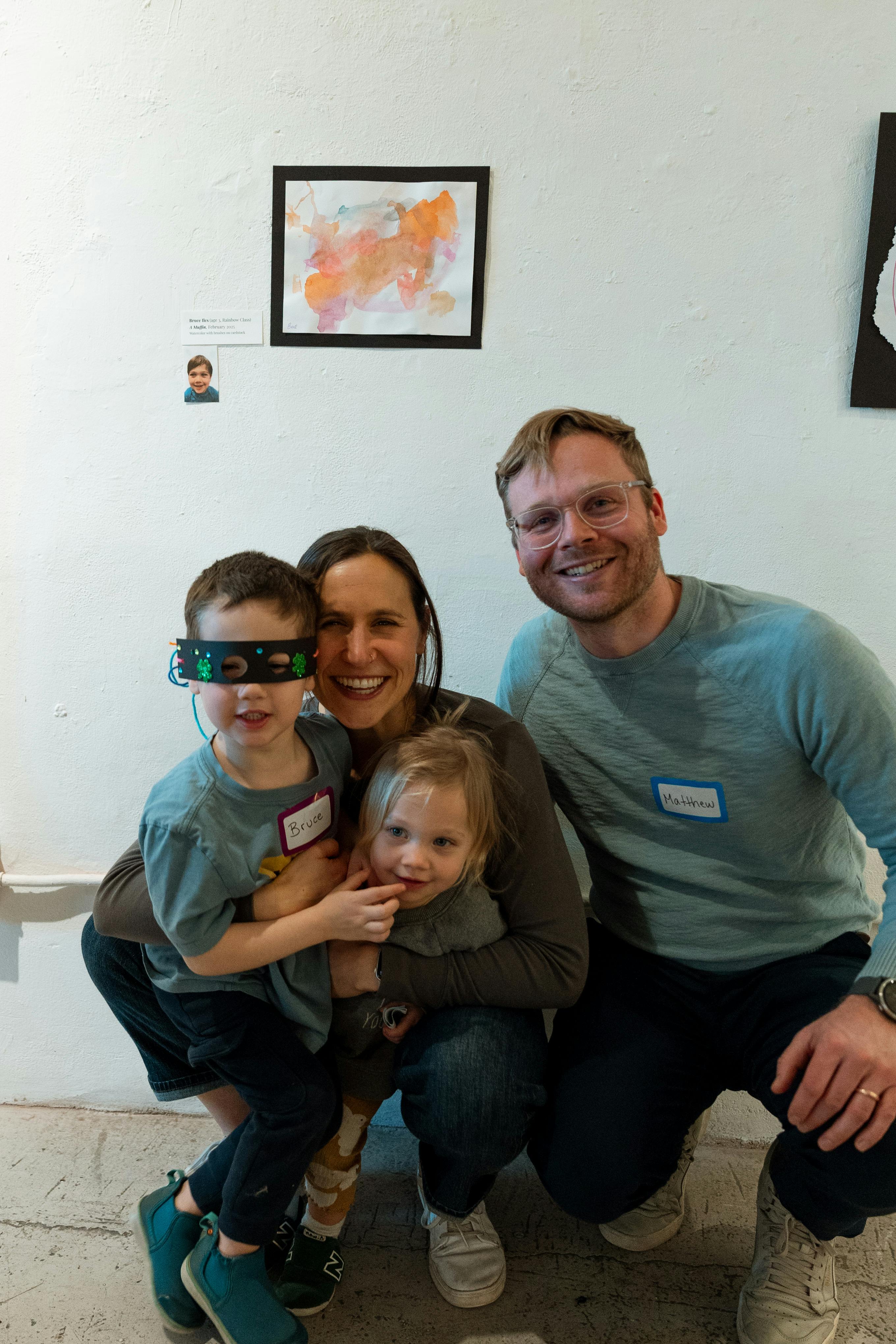 Two adults and two children posing, one child wearing a mask