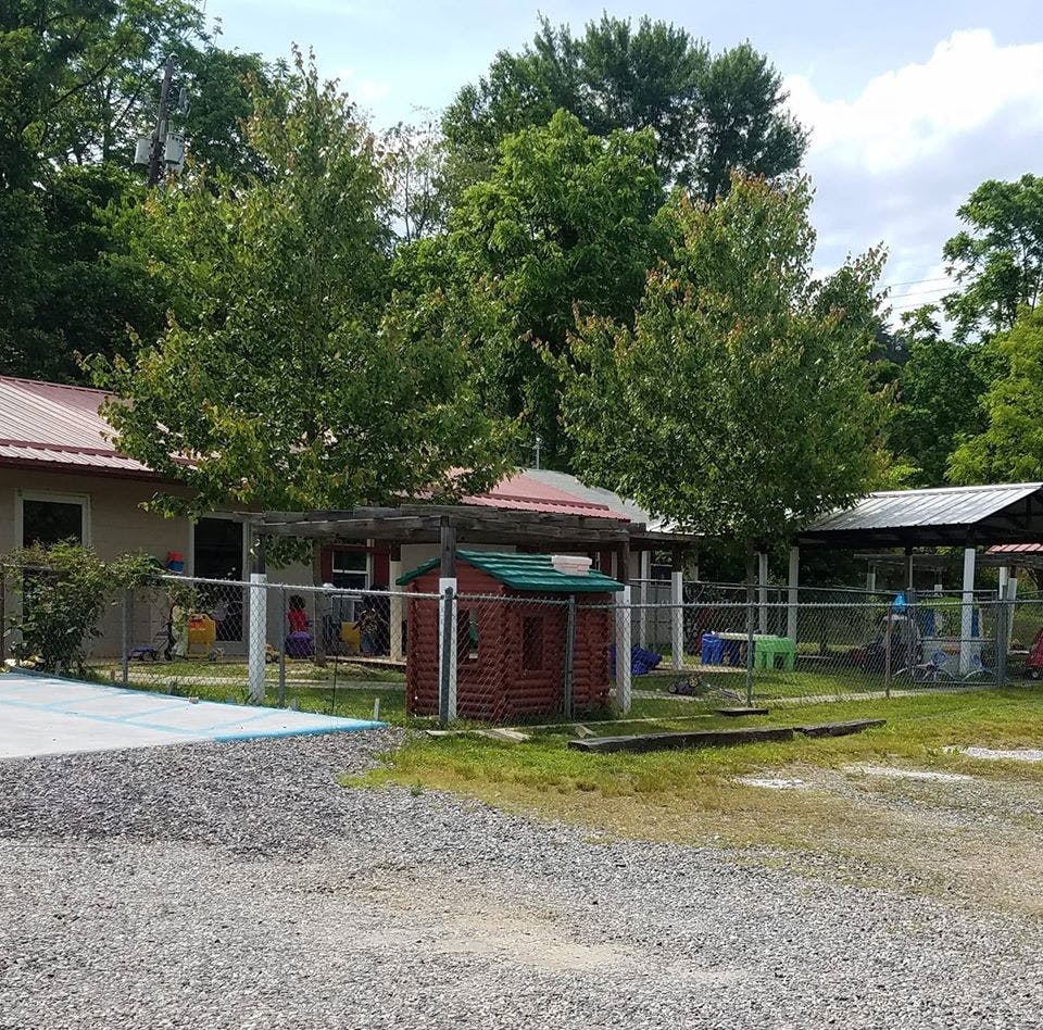 Building with red roof and fenced-in play area