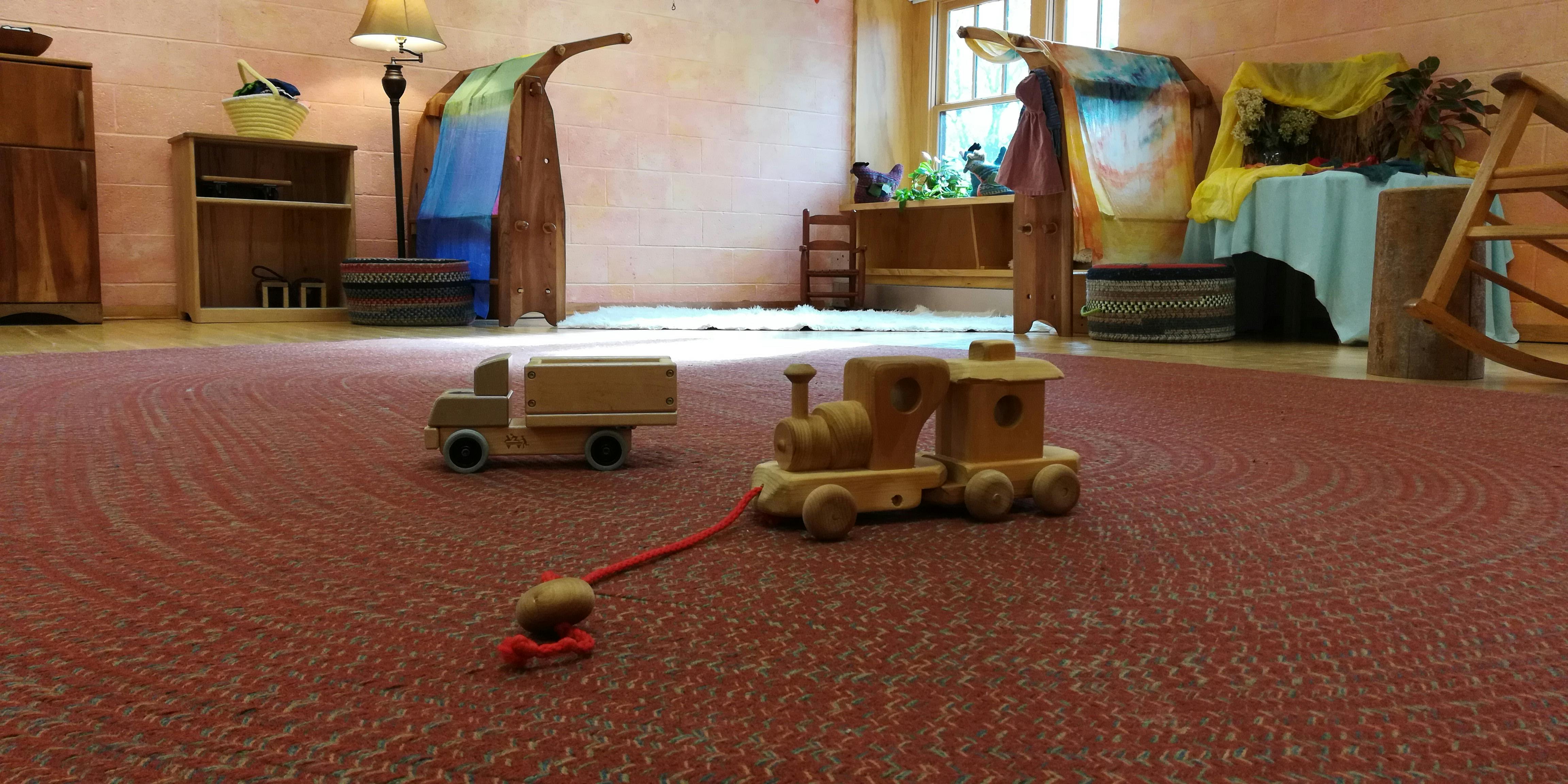 Wooden toy truck and train on a red carpet