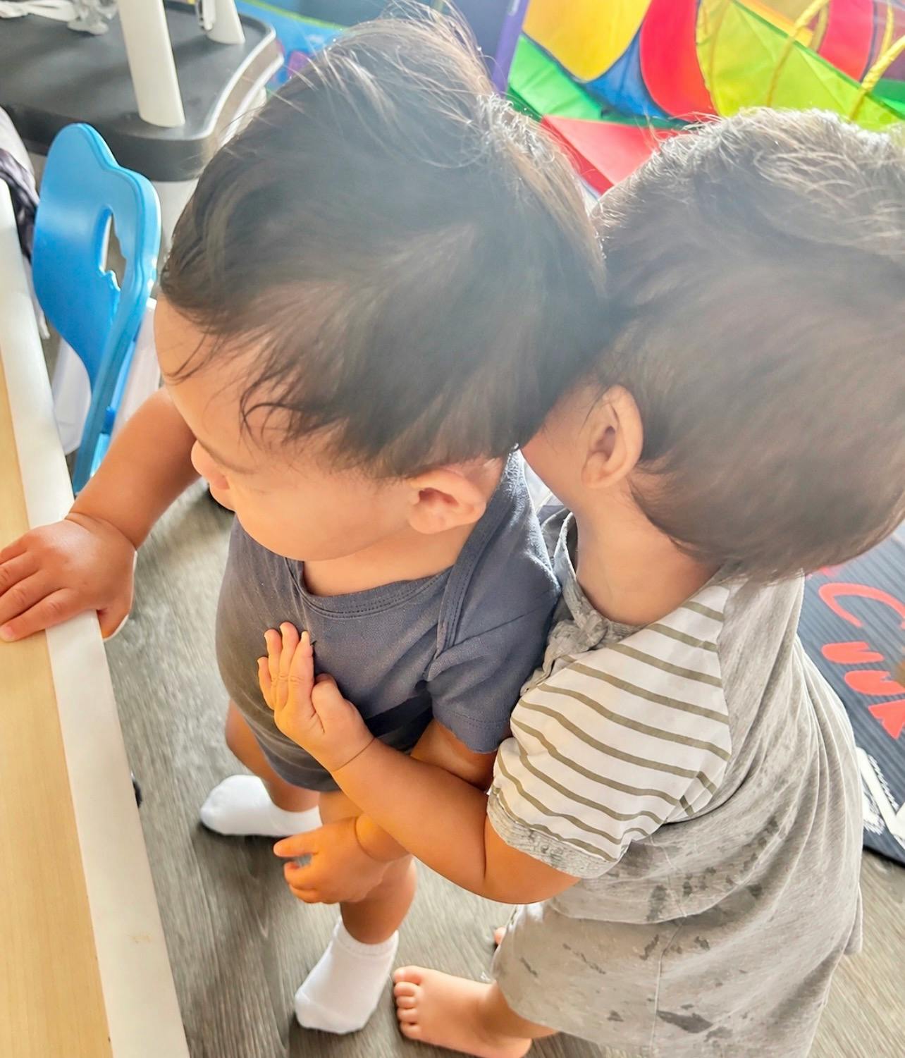 Two children standing close together indoors