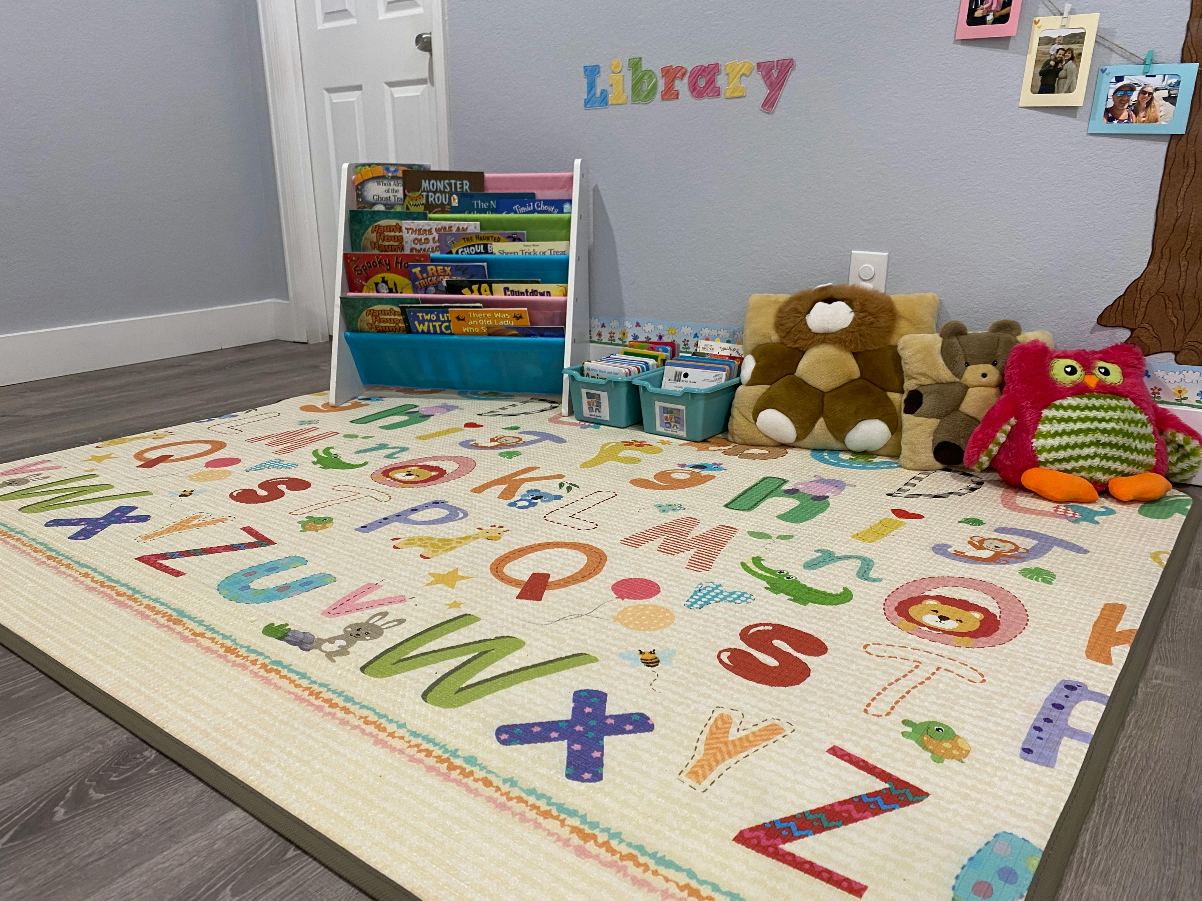 Alphabet rug with a bookshelf and stuffed animals in a room