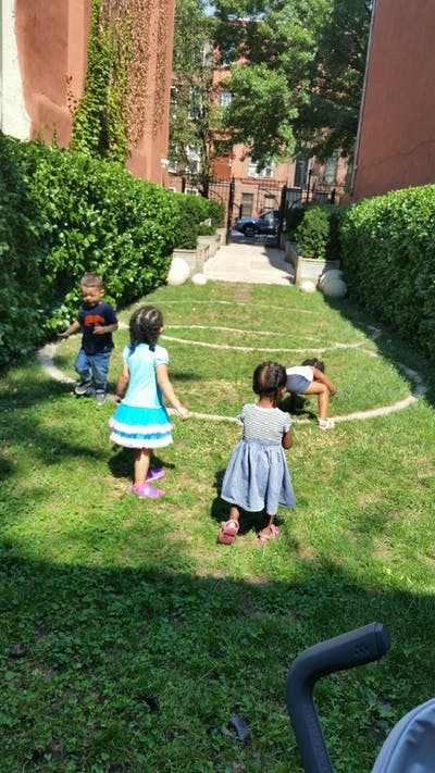 Three children playing on a grassy lawn with white circles drawn circles