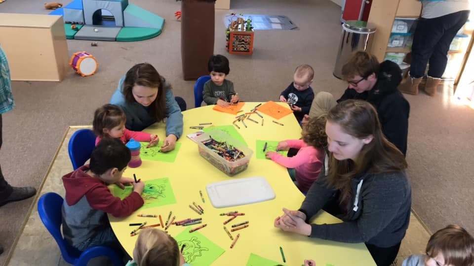 People and children drawing at a table