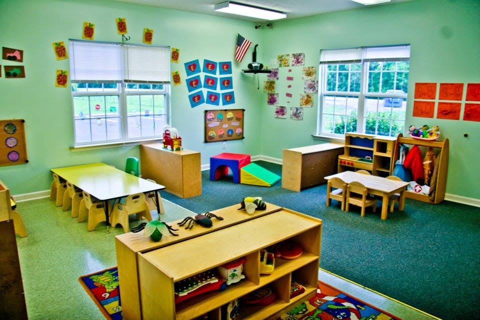 Classroom with small tables, chairs, and storage units