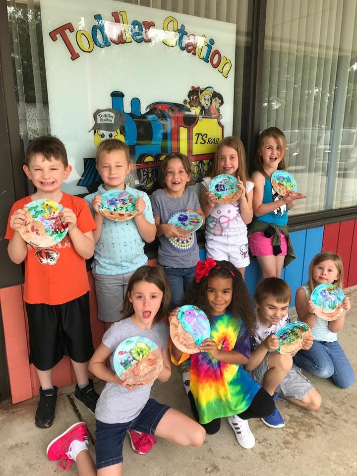 Group of children holding up painted paper plates