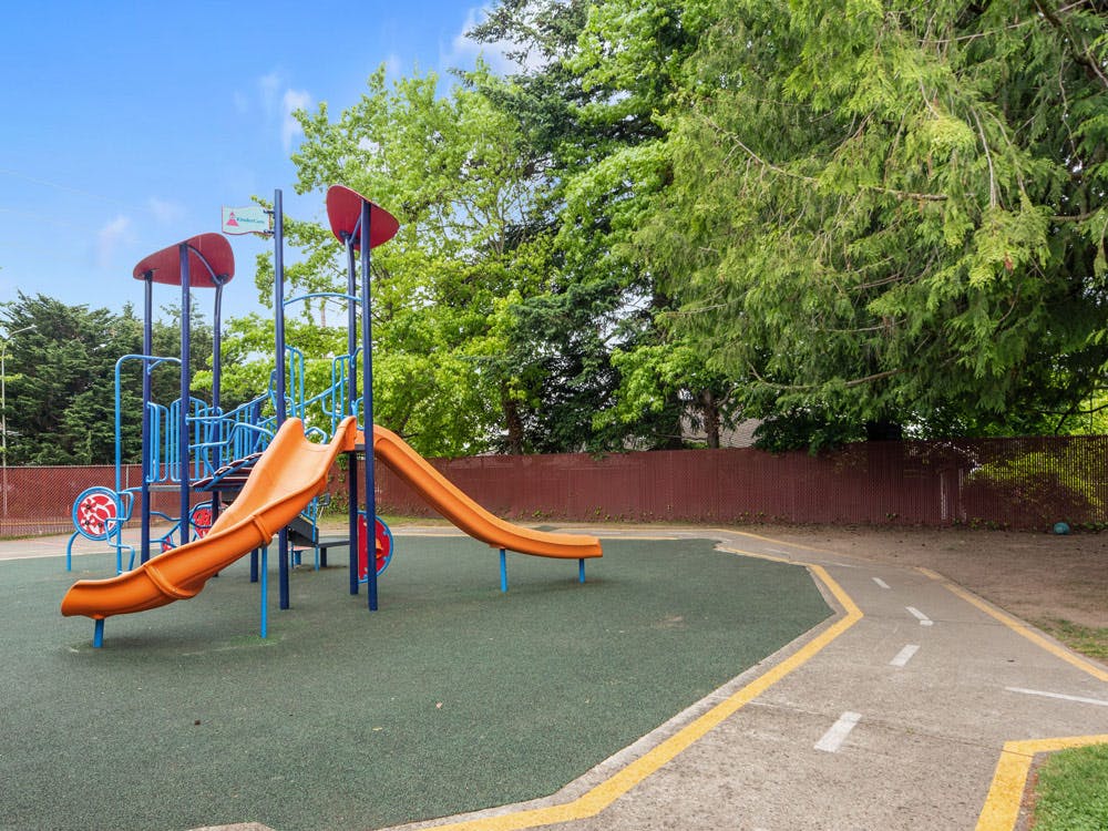 Orange and blue playground slide set on green ground