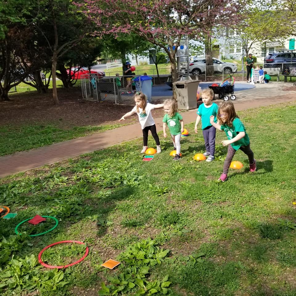 Children playing on grass with cones and hoops