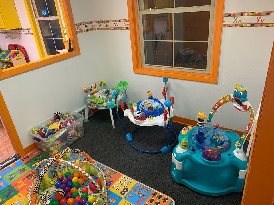 Playroom with various infant activity centers and toys