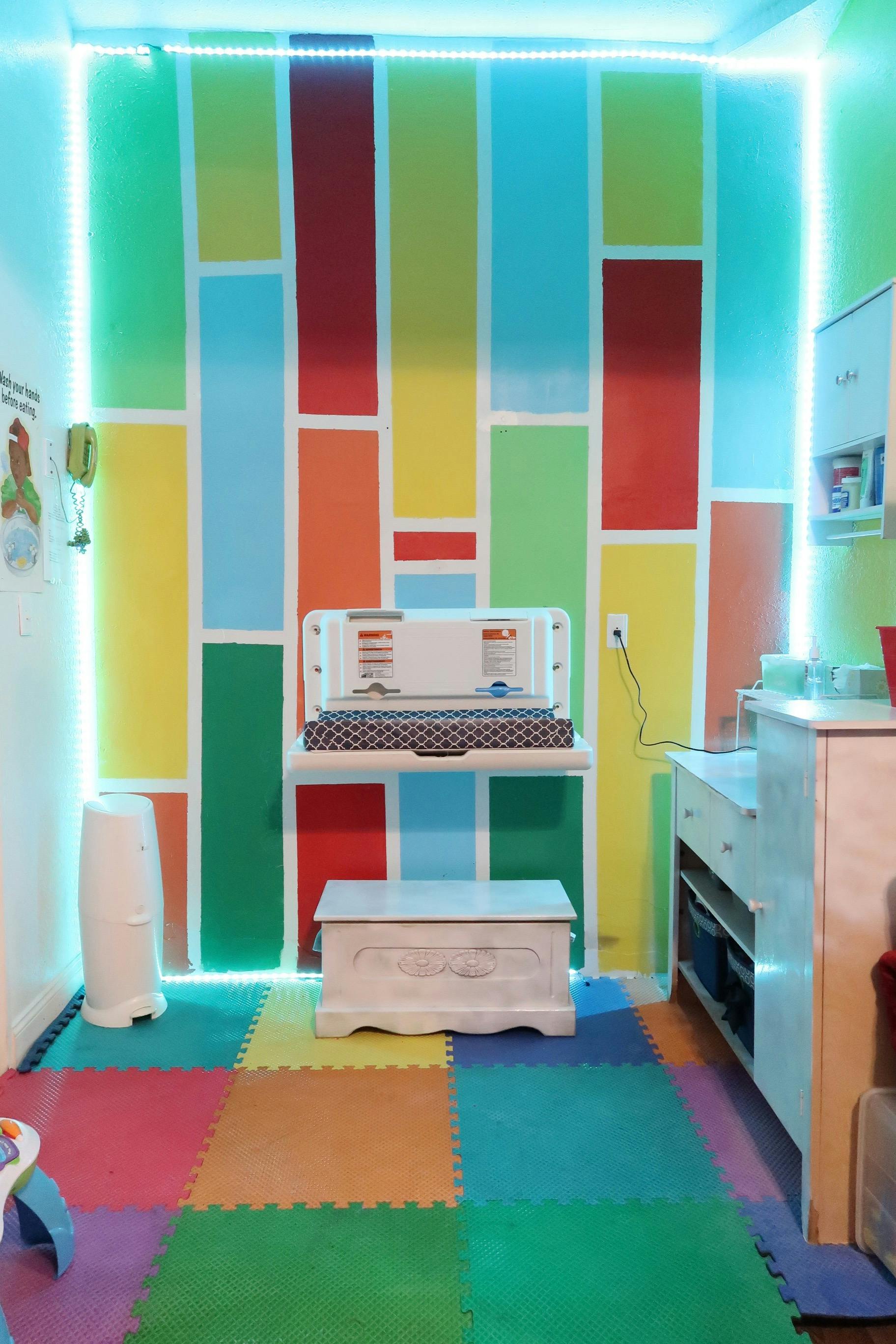 Changing station in a room with colorful walls and floor