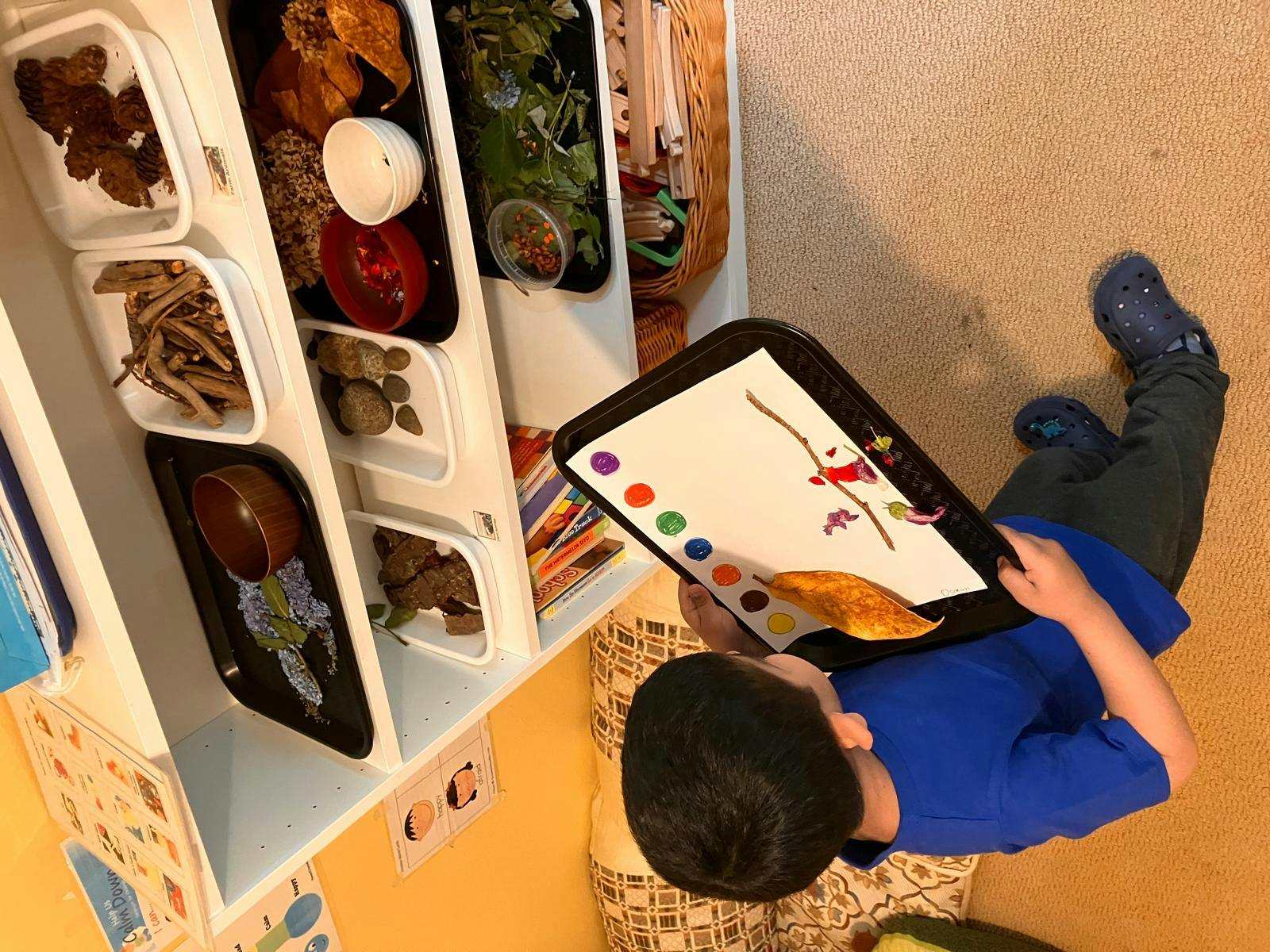 Child painting on a tray in a classroom