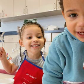 Two children in a kitchen-like setting
