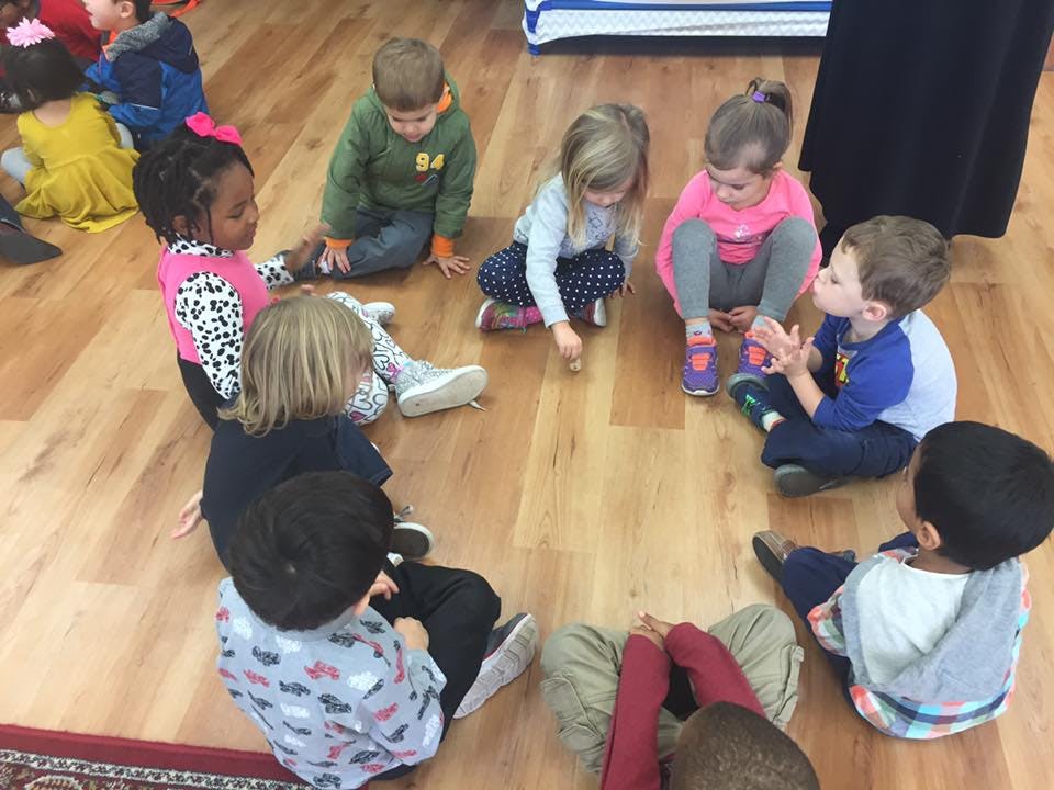 Children sitting in a circle on a wooden floor