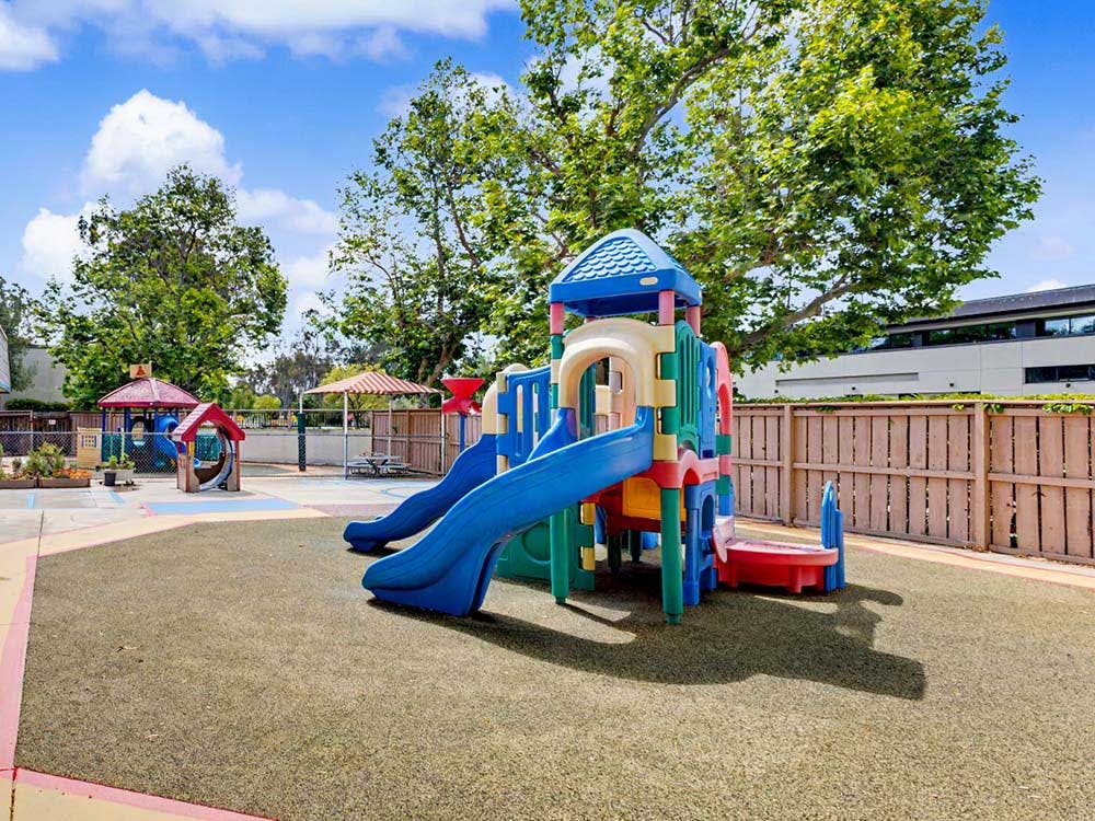 Colorful playground structure with slides on a green mat