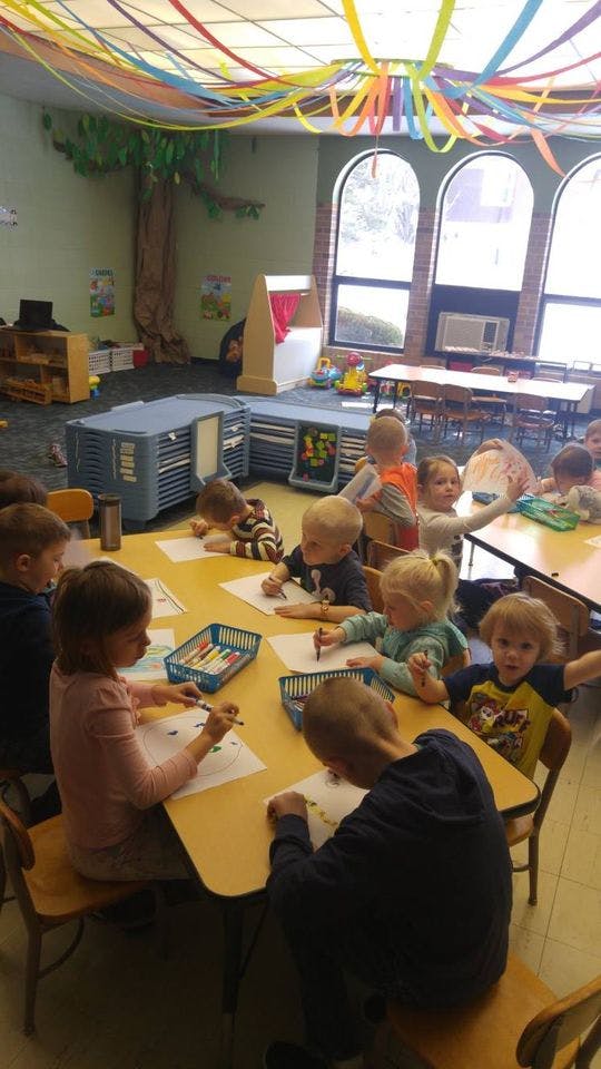 Children drawing at tables in a classroom