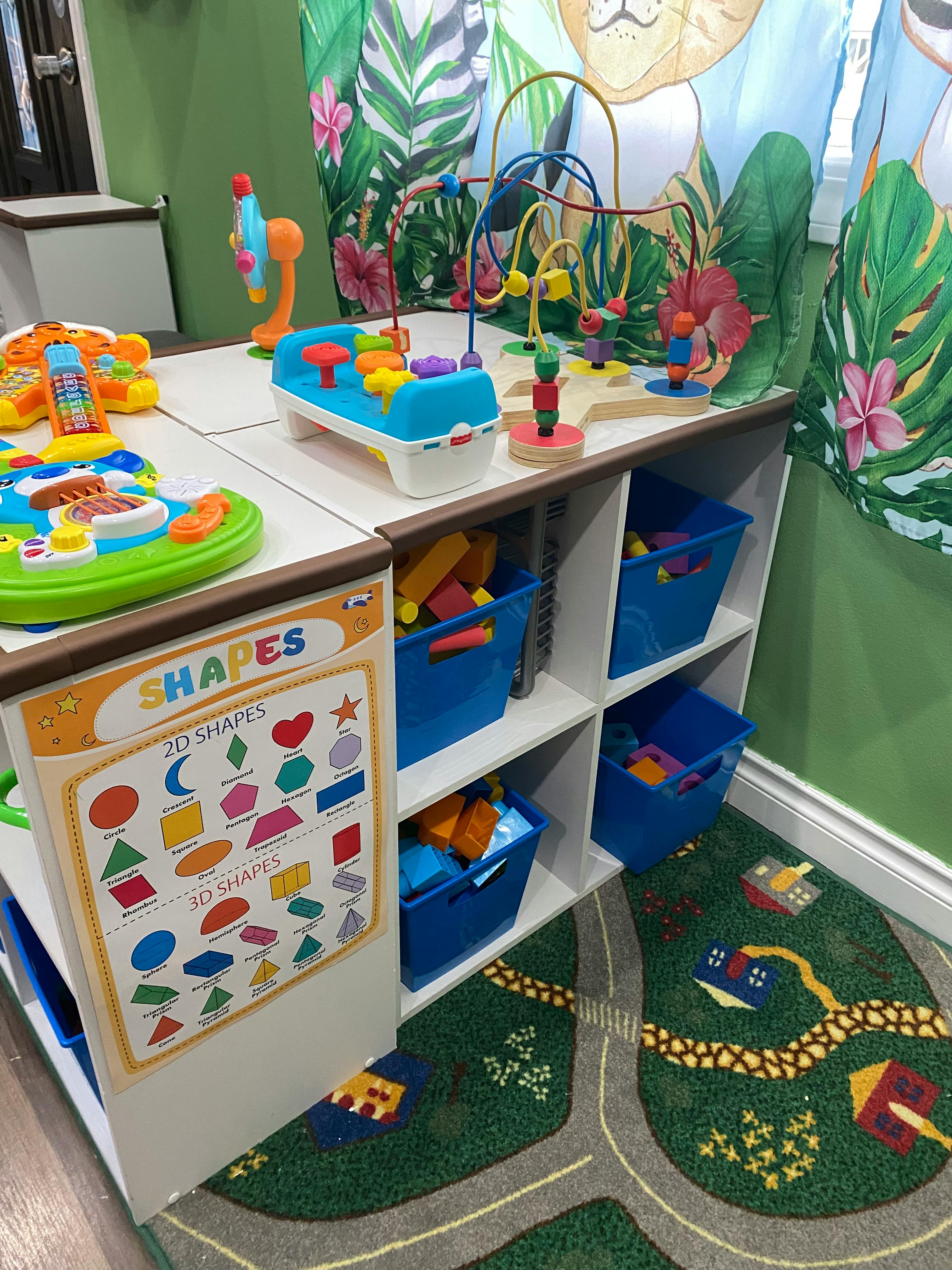 Children's play area with toys on shelves and a rug with roads