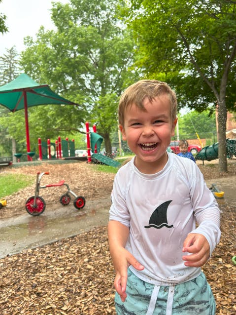 Child in a shark shirt playing in the rain