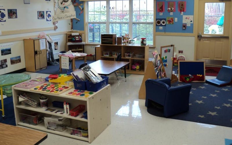 A classroom with learning materials, shelves, and small tables