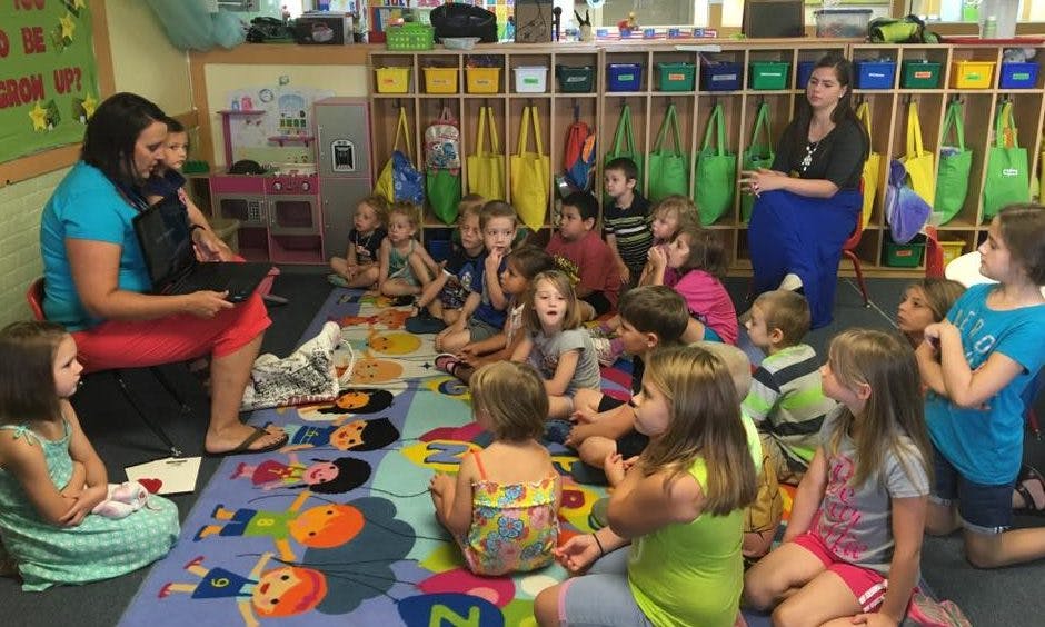 Adult reading to children in a classroom