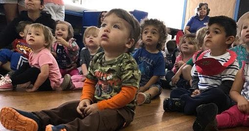 Group of children sitting on the floor looking up