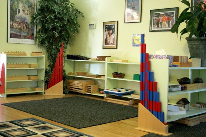 Classroom with shelves of learning materials and a rug on the floor