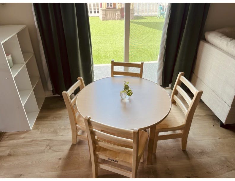 Small wooden table with four chairs in a room with a window