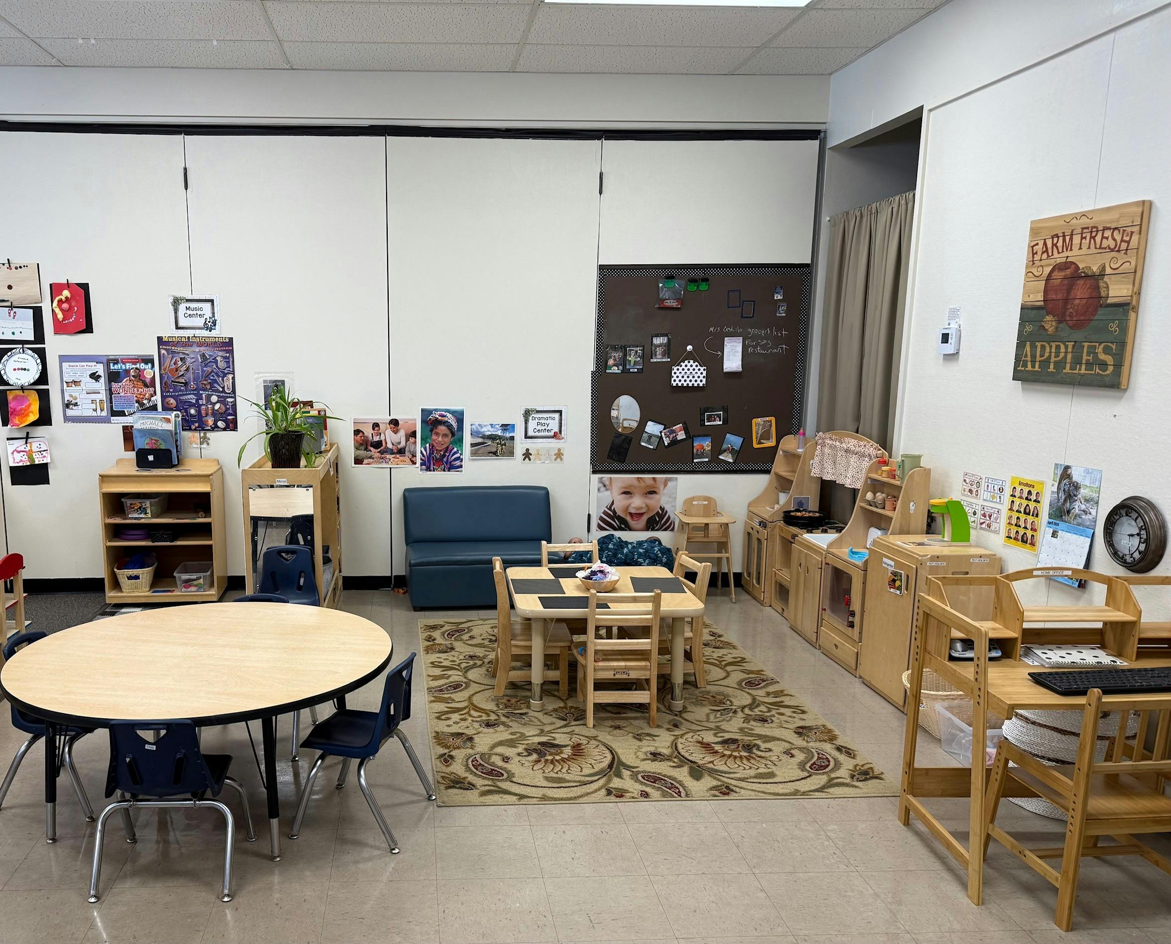 A classroom with tables and chairs, a sofa, and play kitchen furniture
