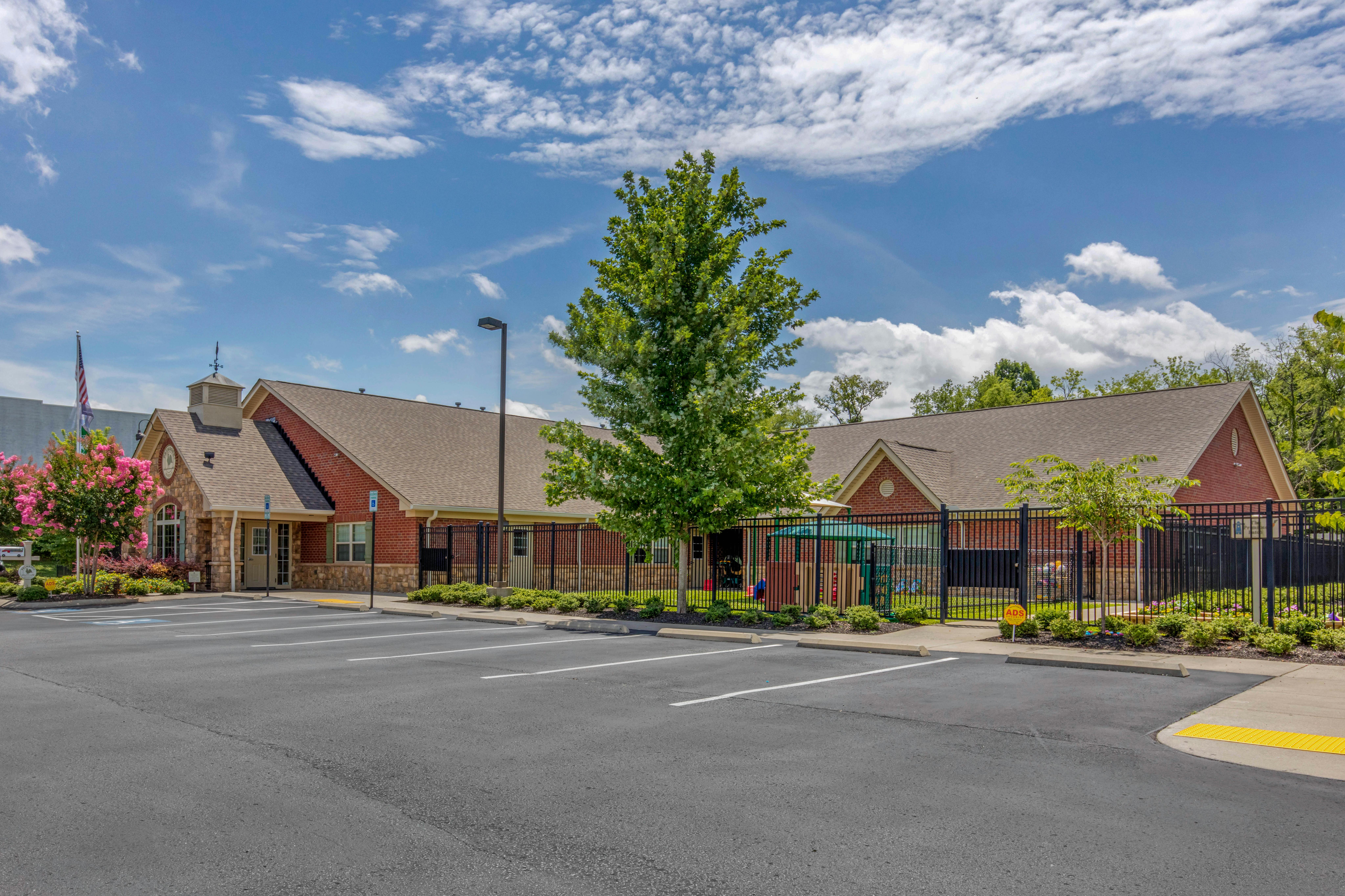 Exterior view of a childcare center with a parking lot and playground