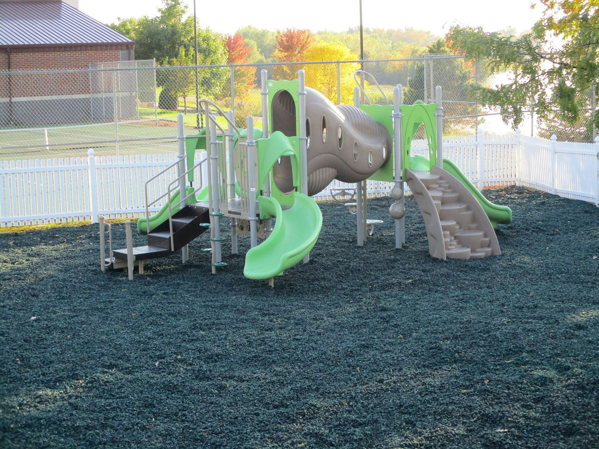 Playground structure with slides and stairs on a rubberized surface