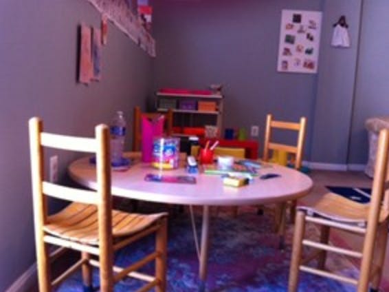 Round table with art supplies and chairs in a room