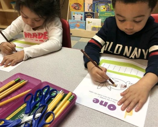 Two children drawing and coloring at a table