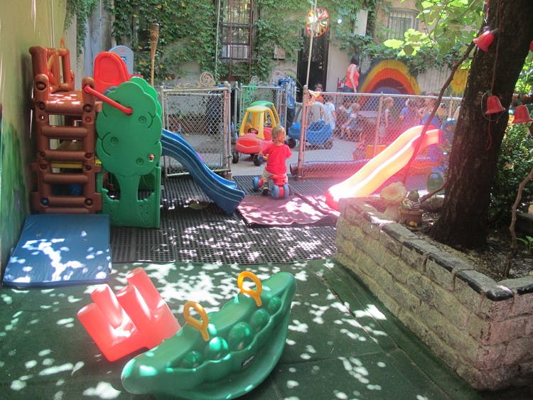 Child playing on a colorful outdoor playground with slides and climbing structures