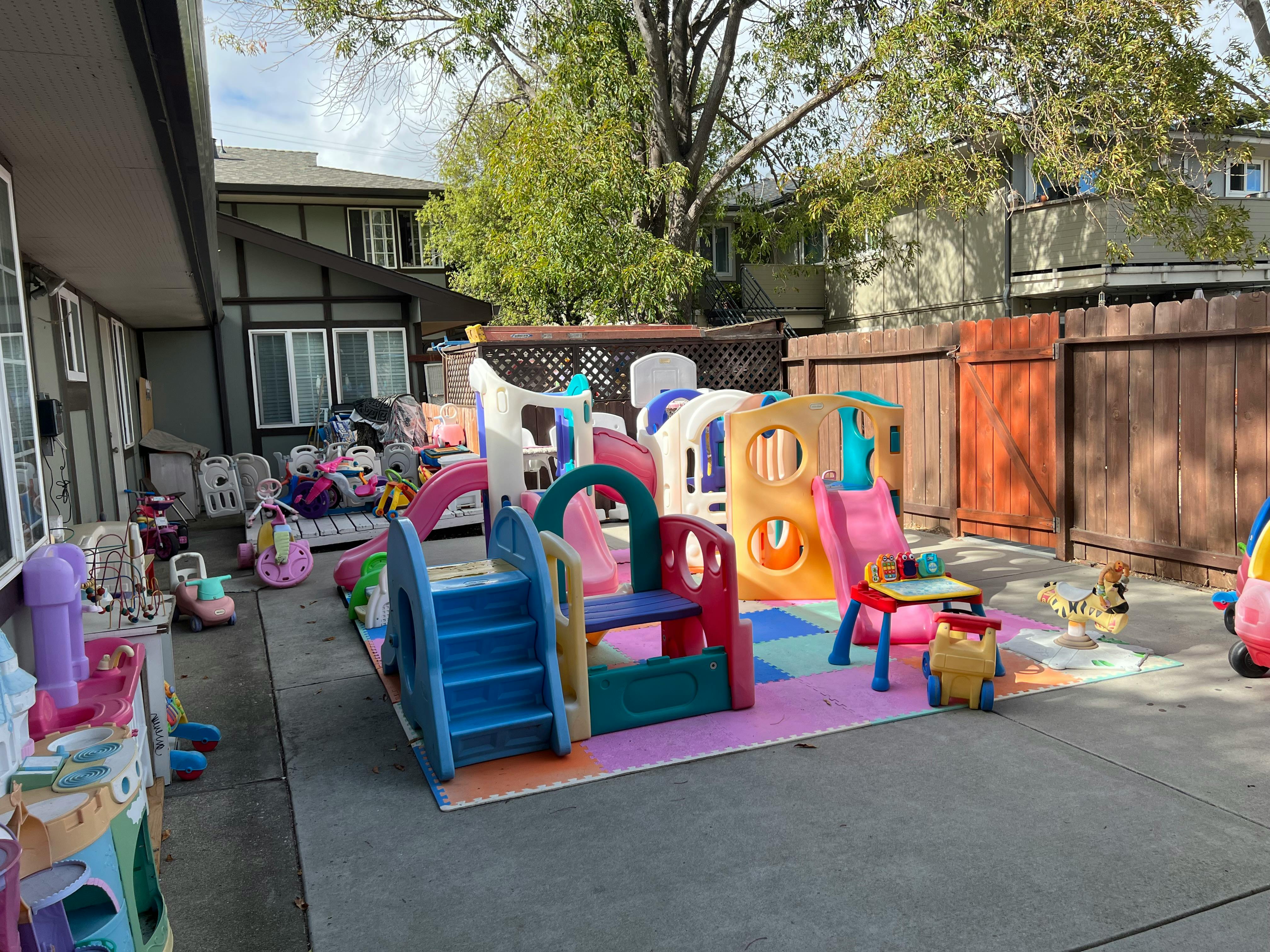 Outdoor playground with colorful slides and play structures on a padded surface