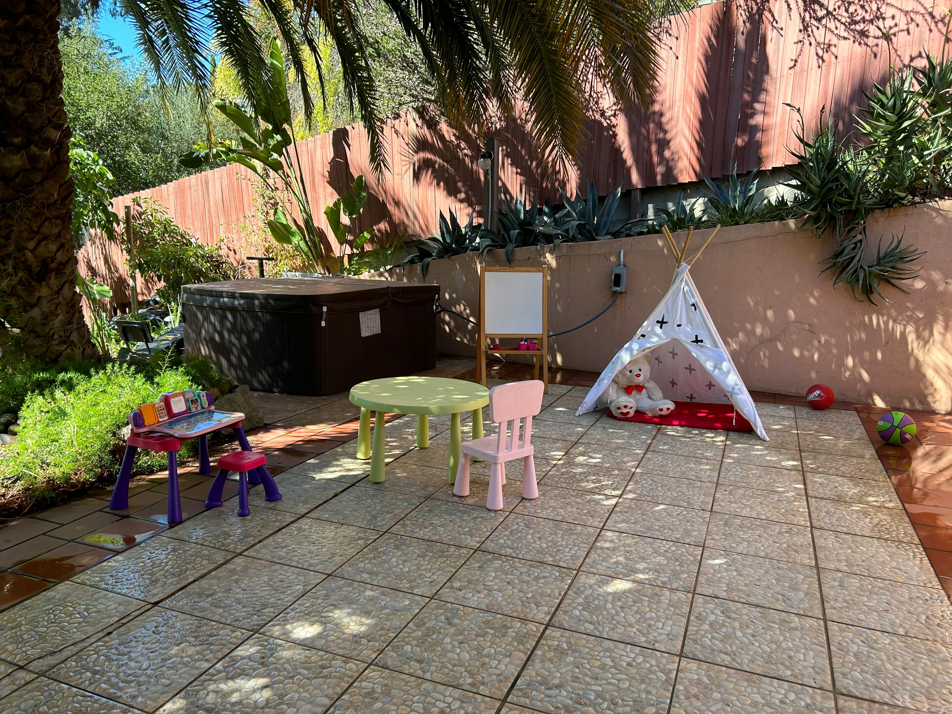 Outdoor patio with children's play furniture and a small teepee