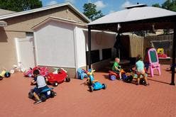 Children playing with ride-on toys outdoors