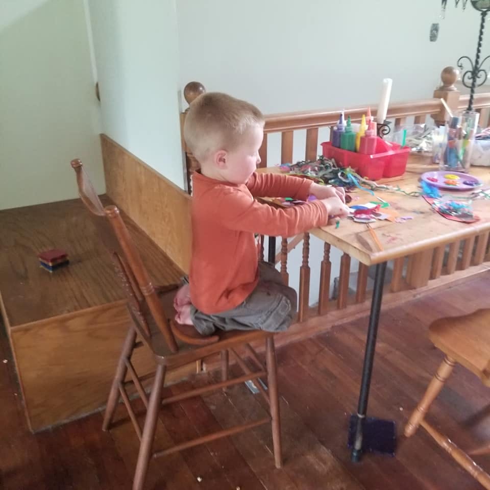 Child sitting at a table doing an art project