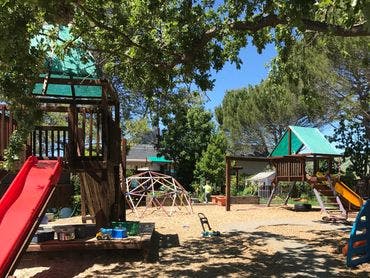 Outdoor playground with slides, climbing structures, and sand