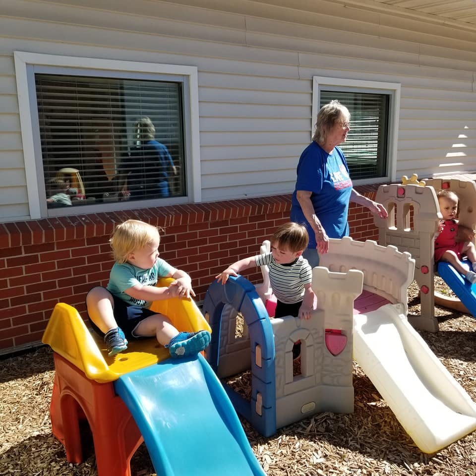 Adult and children playing on outdoor slides and indoor slides