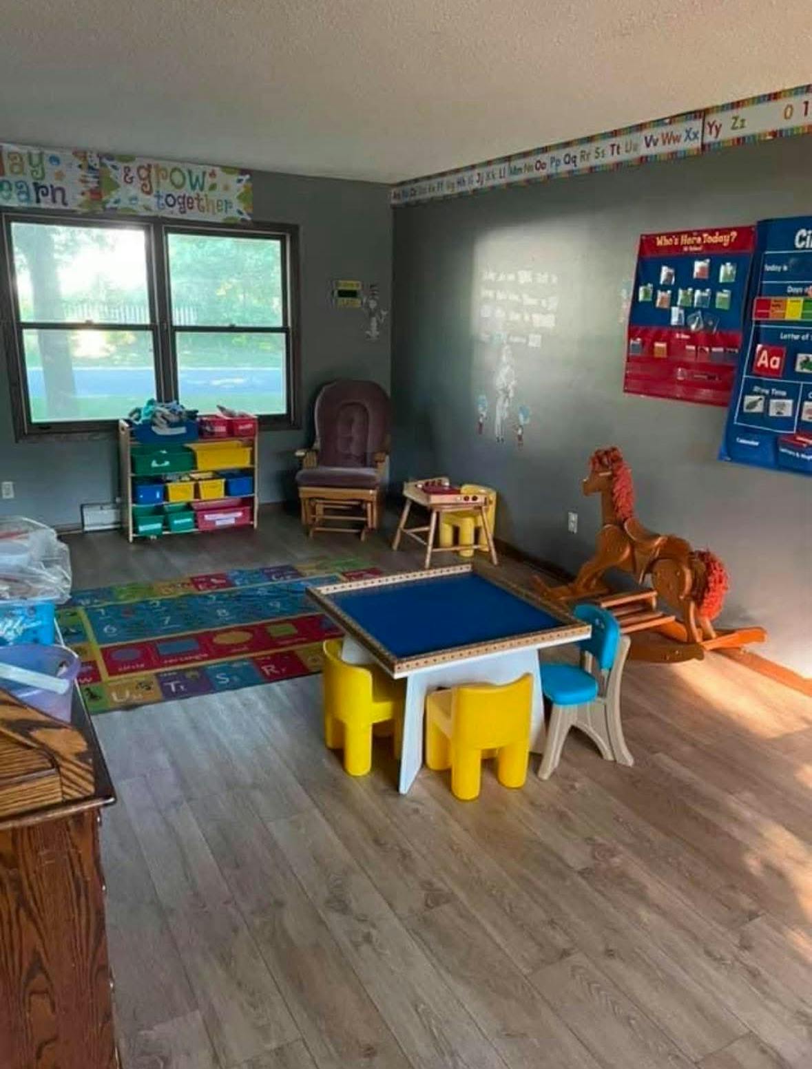 Children's play area with small table and chairs, toy storage, and rocking horse